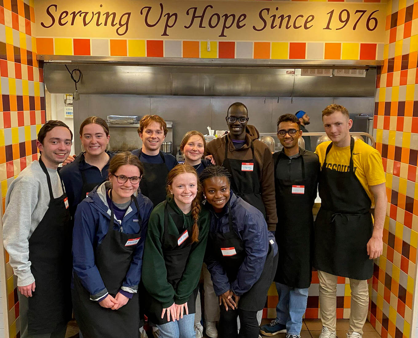 Group of college students volunteering at a soup kitchen.