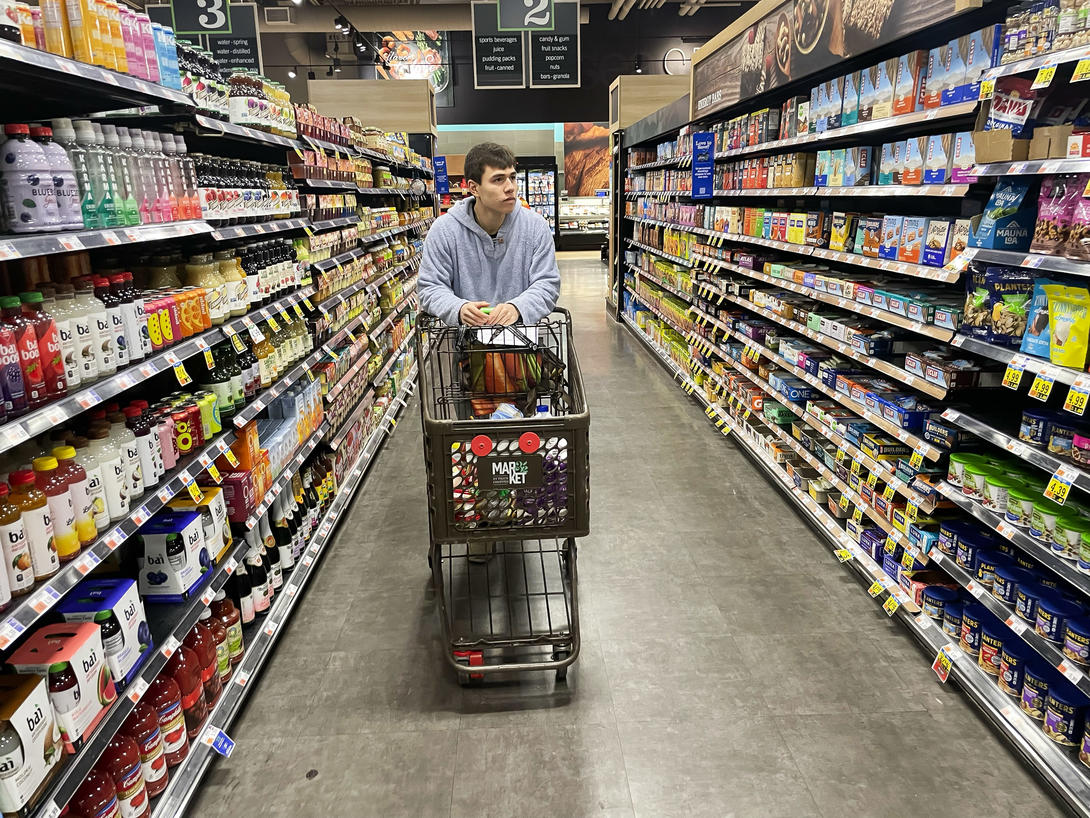 Man pushing shopping cart in grocery store