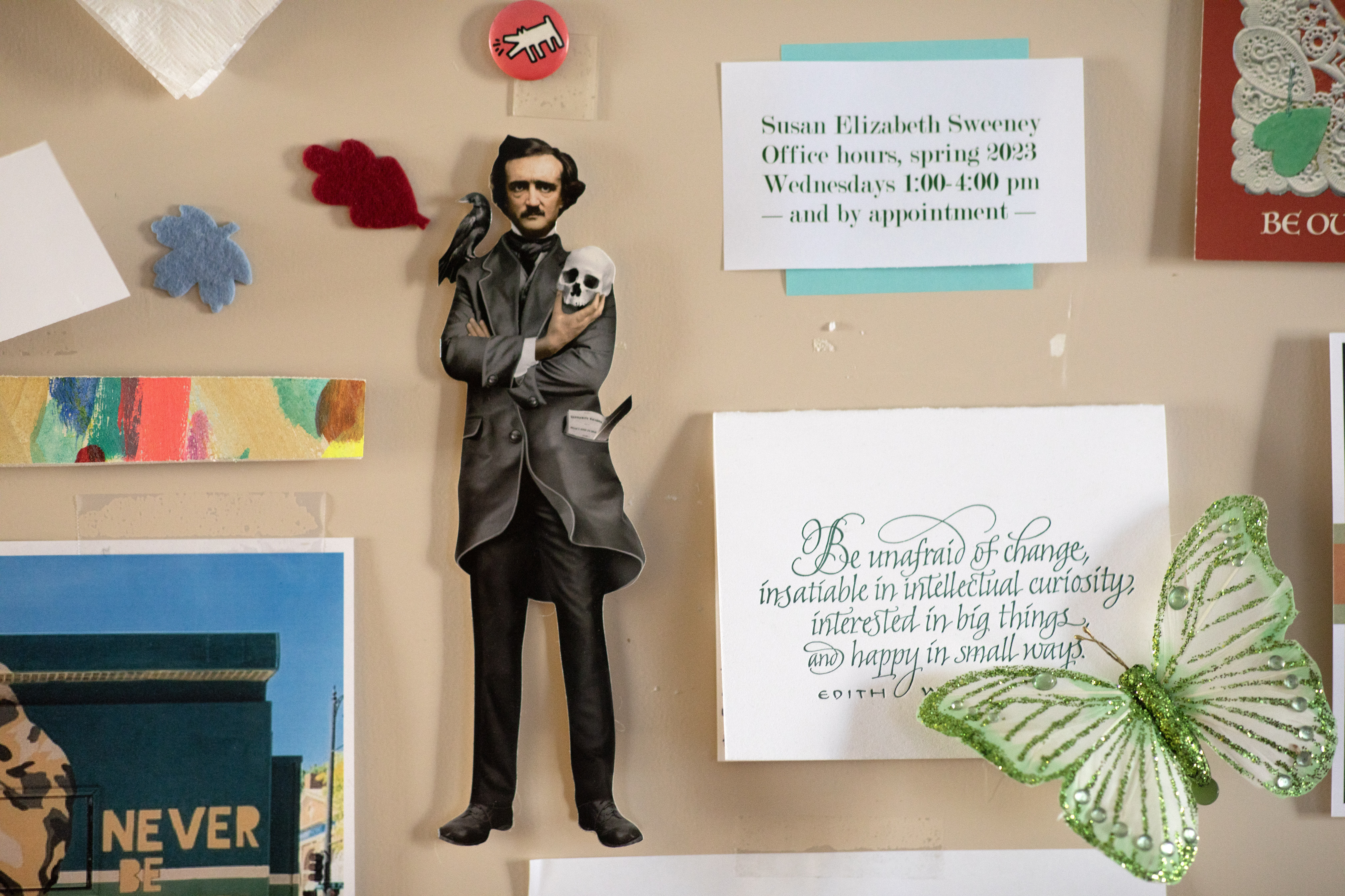 Detail image of an small Edgar Allen Poe figure taped to the door of an office.