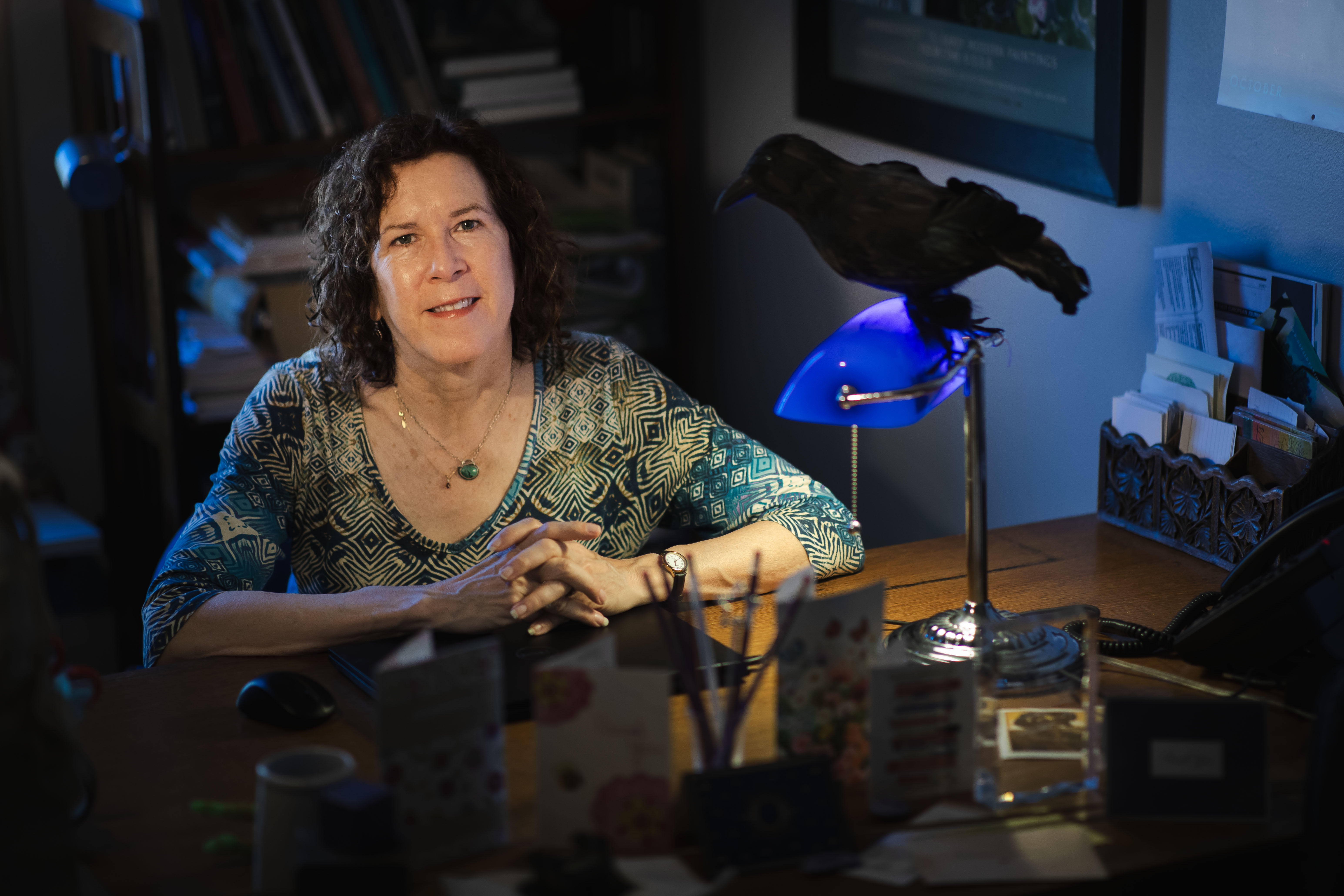 Moody portrait of a literature professor sitting at her desk