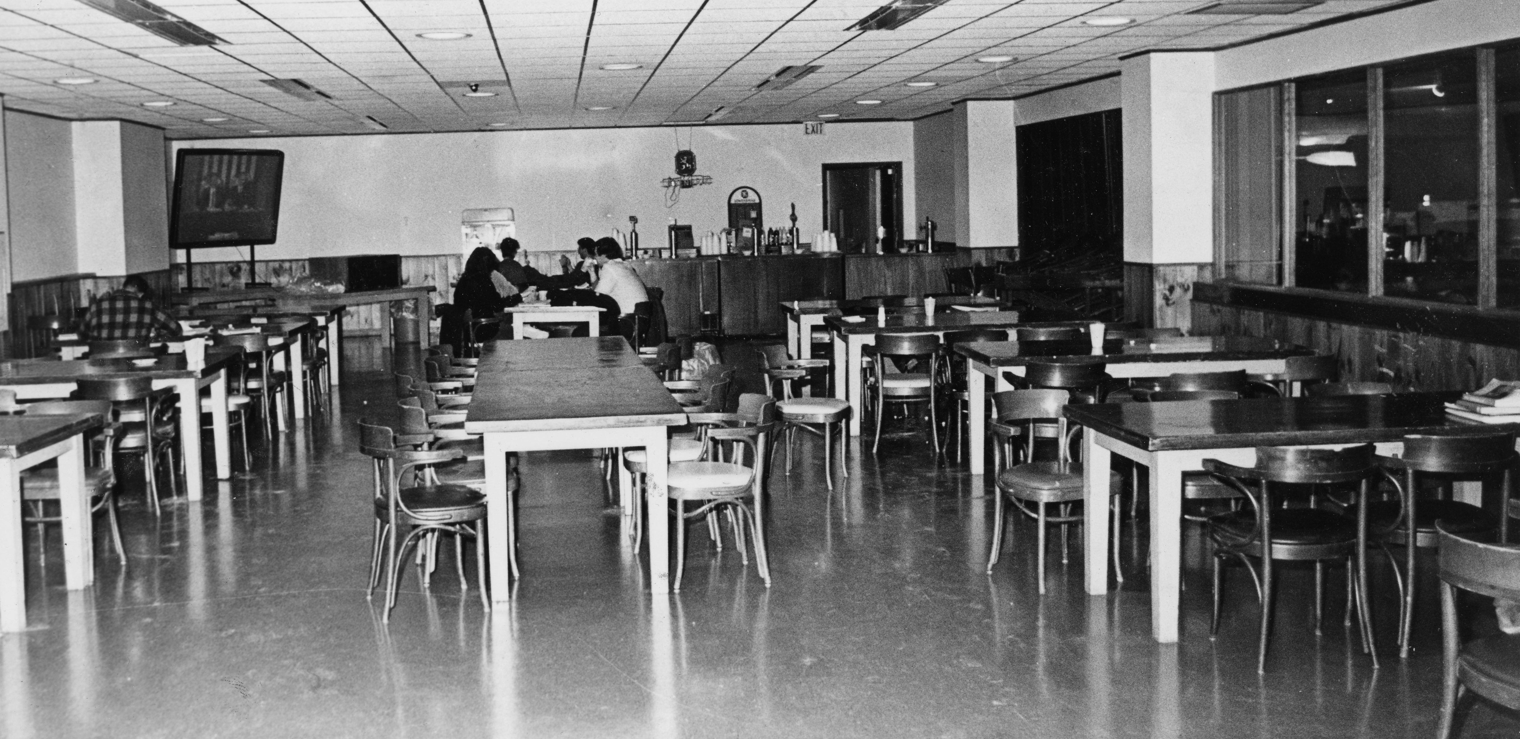 A group of people sitting around tables within a room