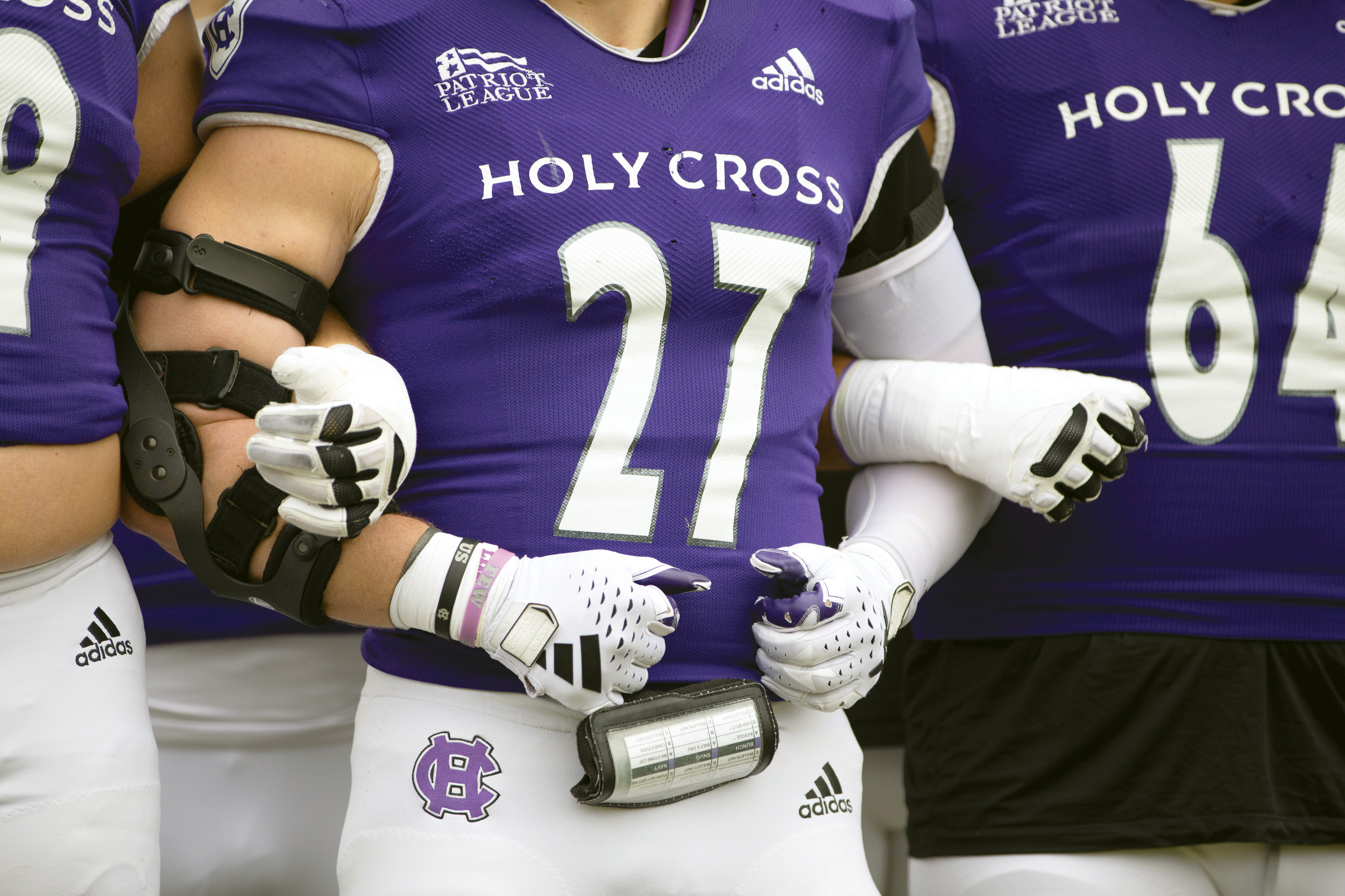A close up of football players with arms linked together