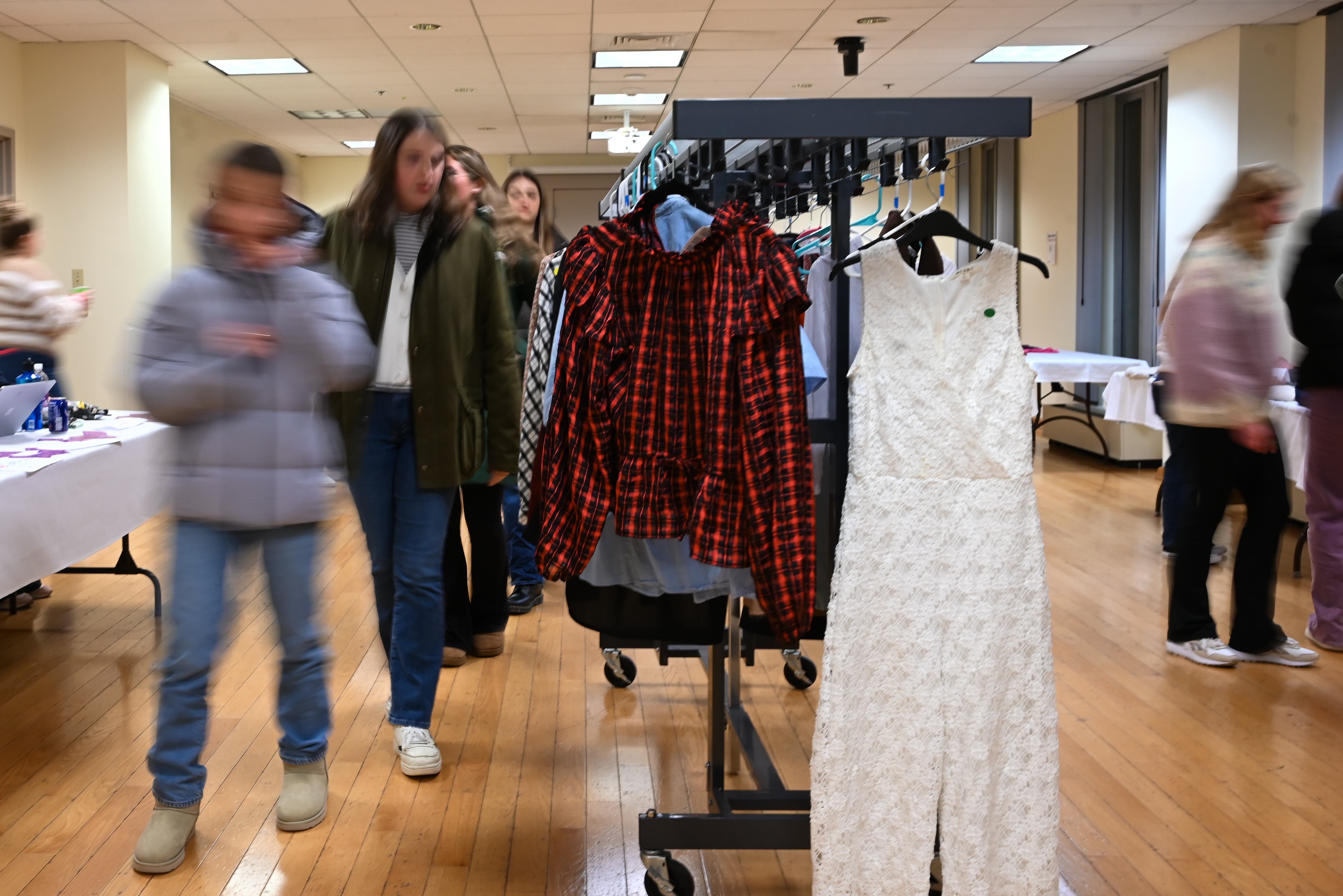 Shoppers look at clothing on racks at a thrift store.