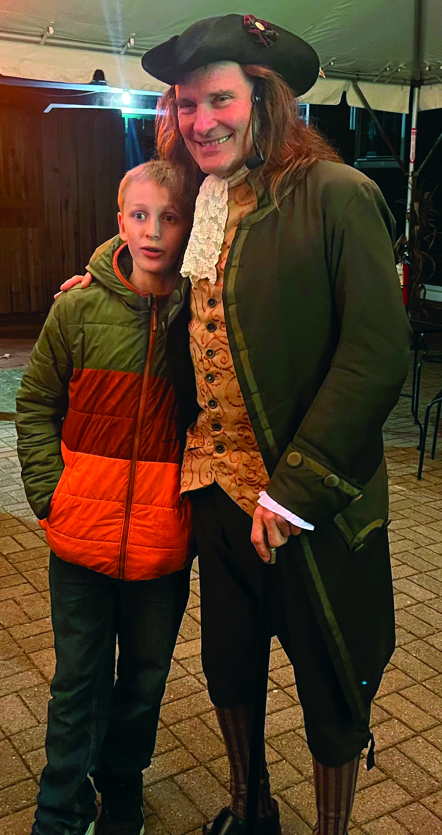 Man in 18th century clothing poses with a young boy.