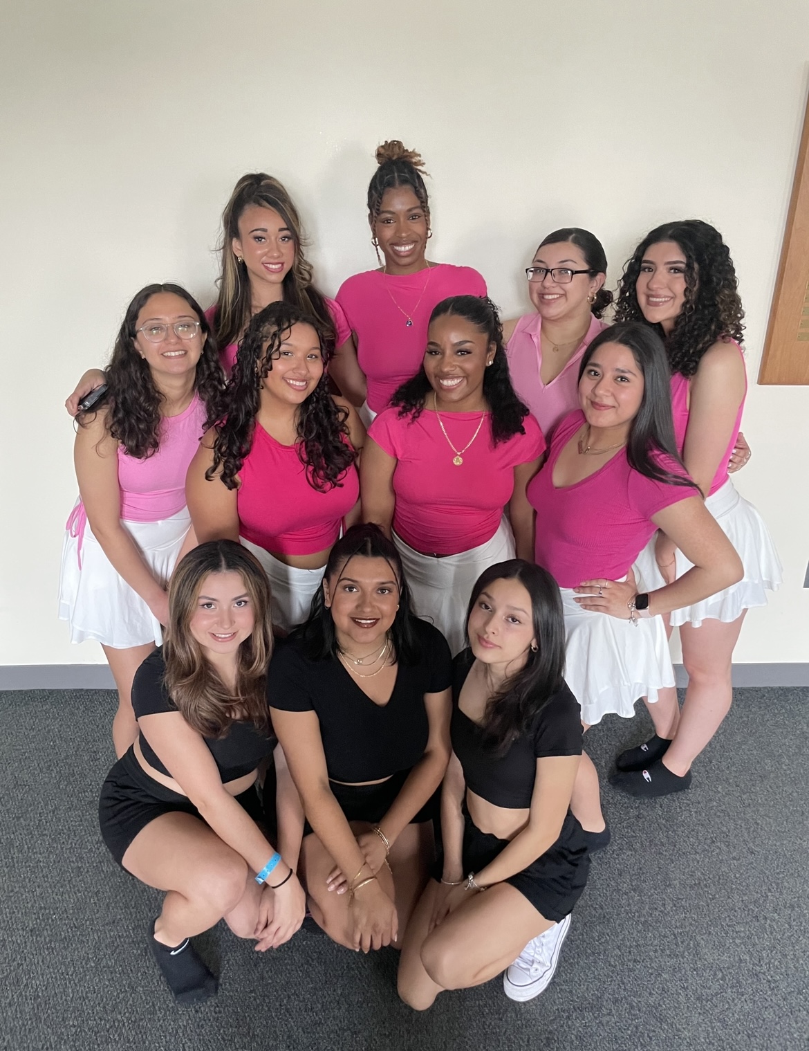 A group photo of about a dozen young women wearing matching tops as part of Latinidad Indentidad