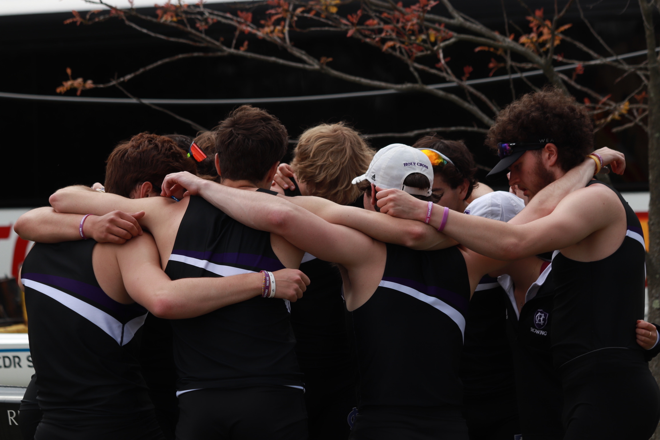 A group of men from the Holy Cross rowing team embrace