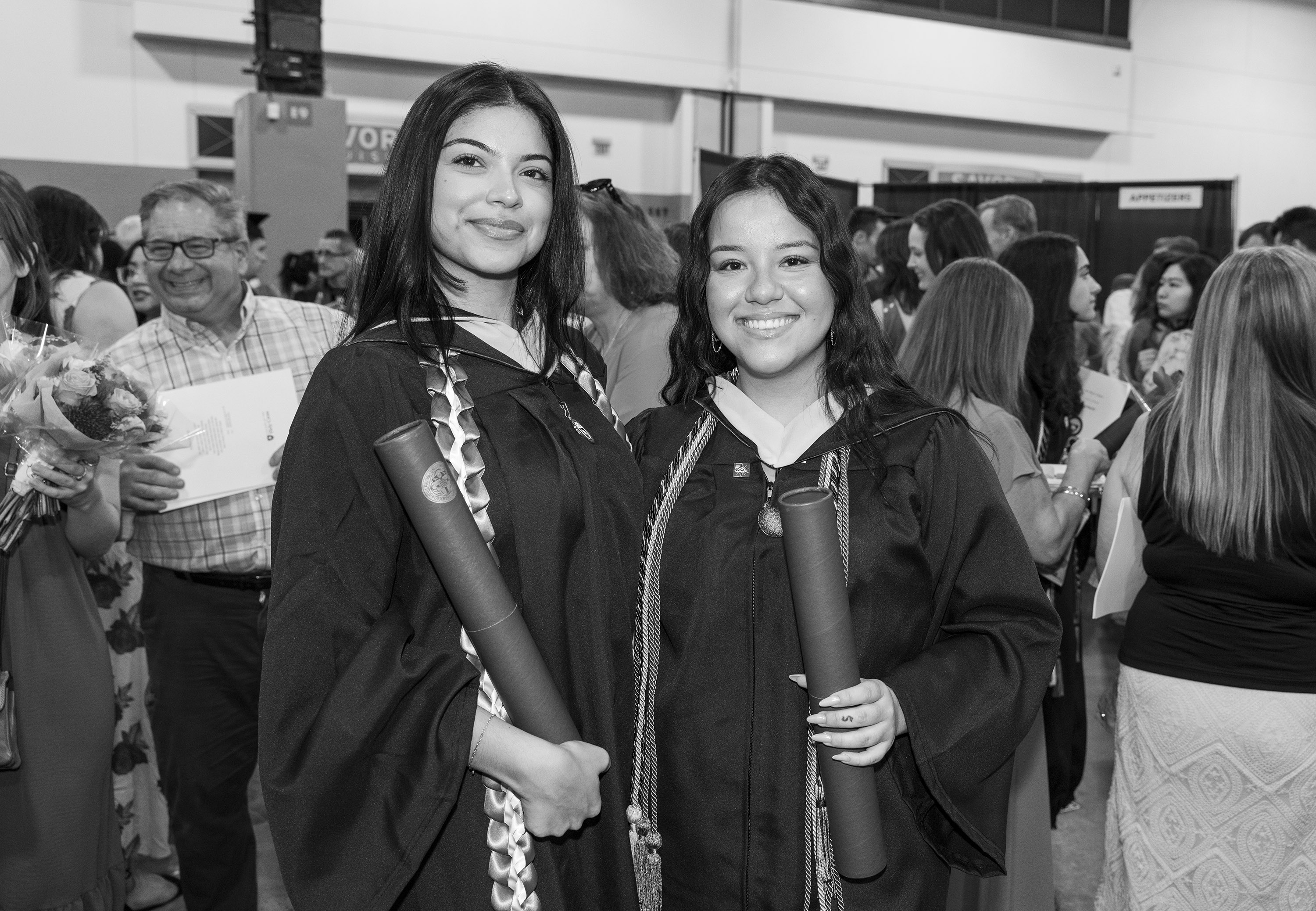 Friends pose together with diplomas after graduation