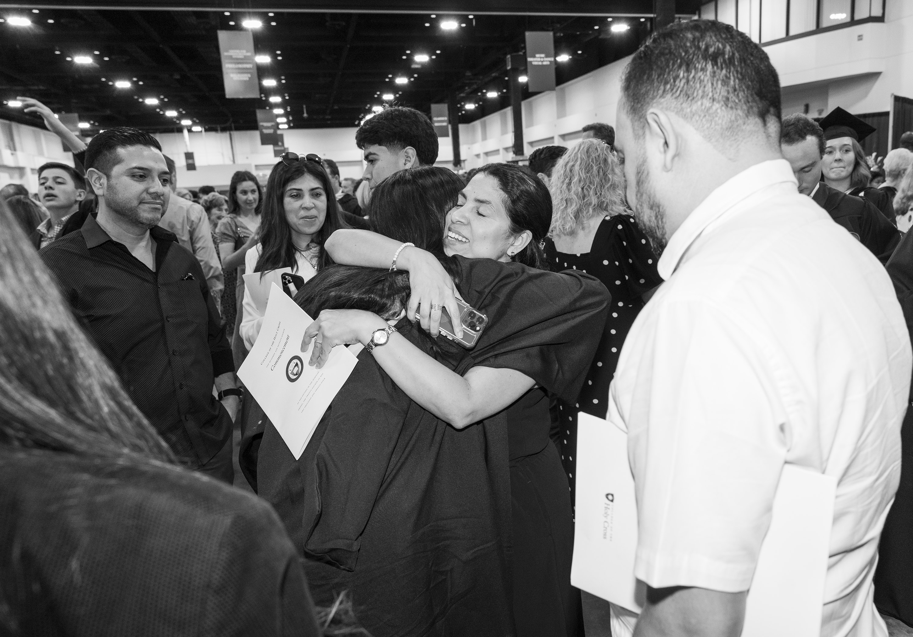 A graduate hugs her aunt after commencement