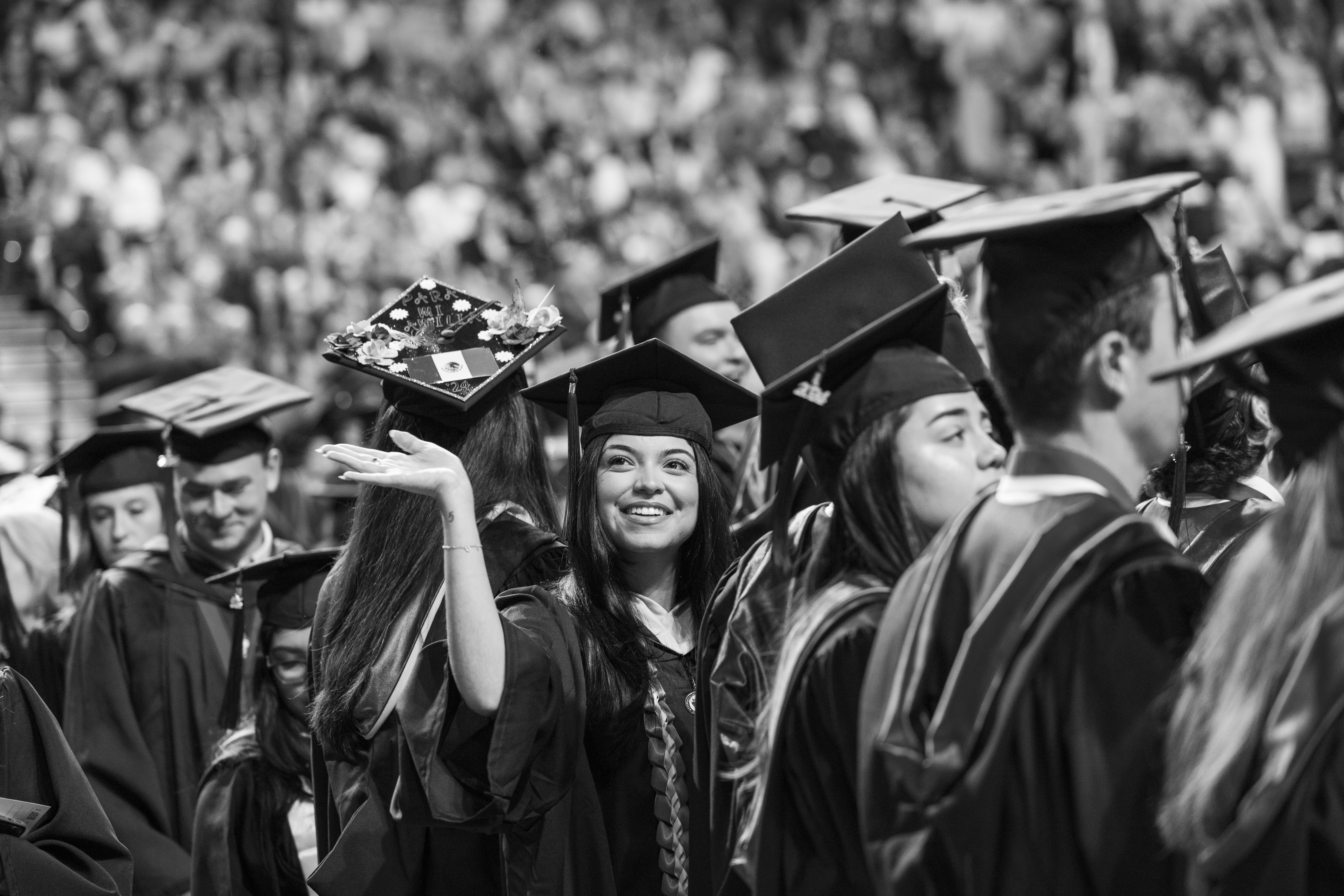 A graduate waves to her family in the crowd