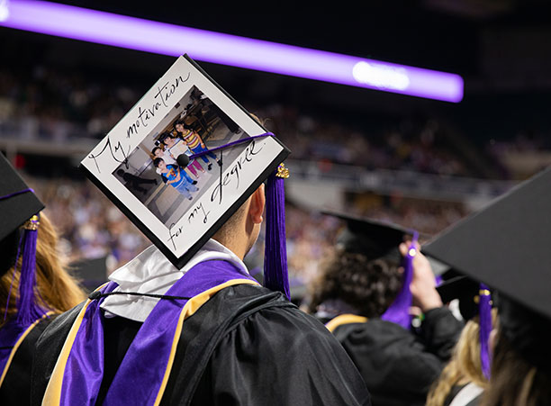 A student wears a decorated mortarboard.