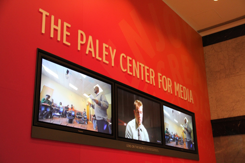 Televisions in the lobby display videos of the arts at Holy Cross.
