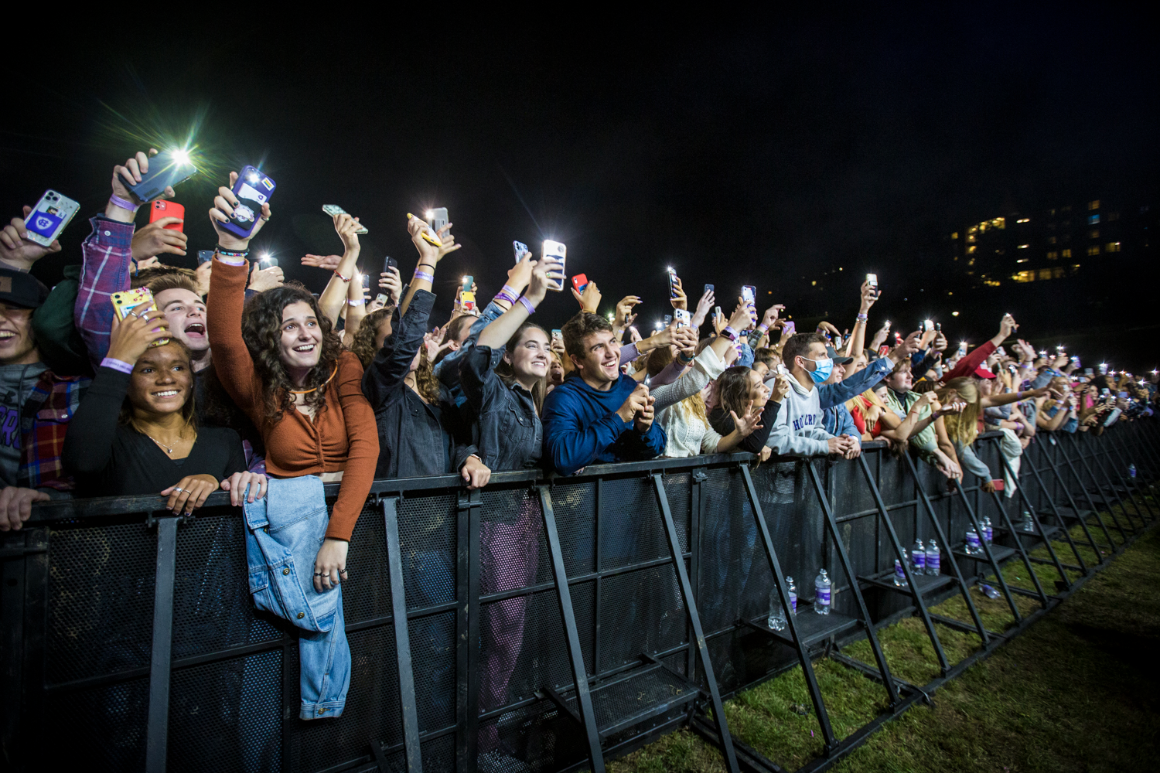 Students watch a concert in a crowd on campus.