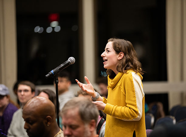 A student stands in the crowd to ask a question