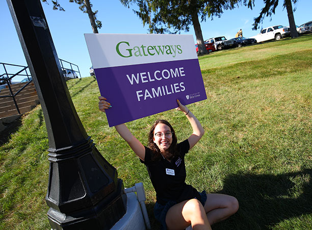 a student holds a welcome sign
