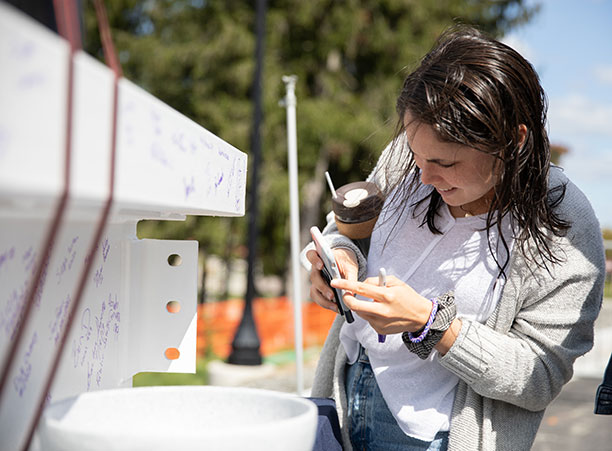 a student takes a photo of the beam