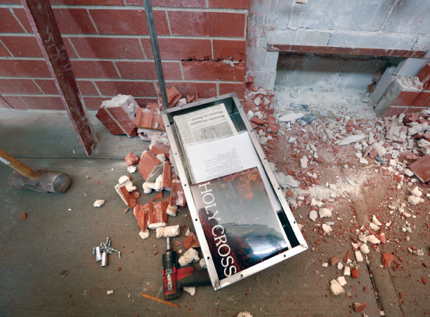 The time capsule lays on the ground around broken brick after being released from wall of Hart Center.