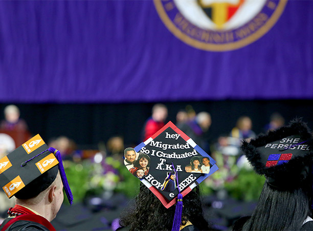 Students wear decorated mortarboards.