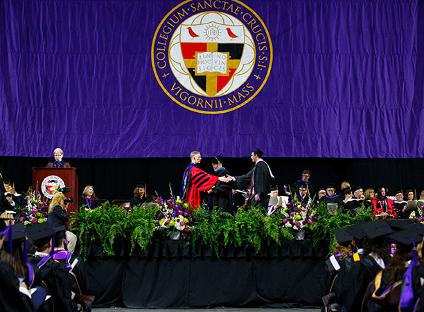 A student receives their diploma from Rev. Philip L. Boroughs, S.J., president of the College.