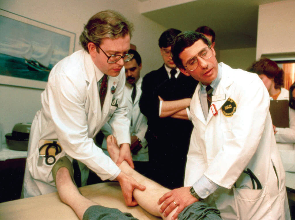 Drs. Lee Hall and Fauci examine a participant in an early AIDS study.