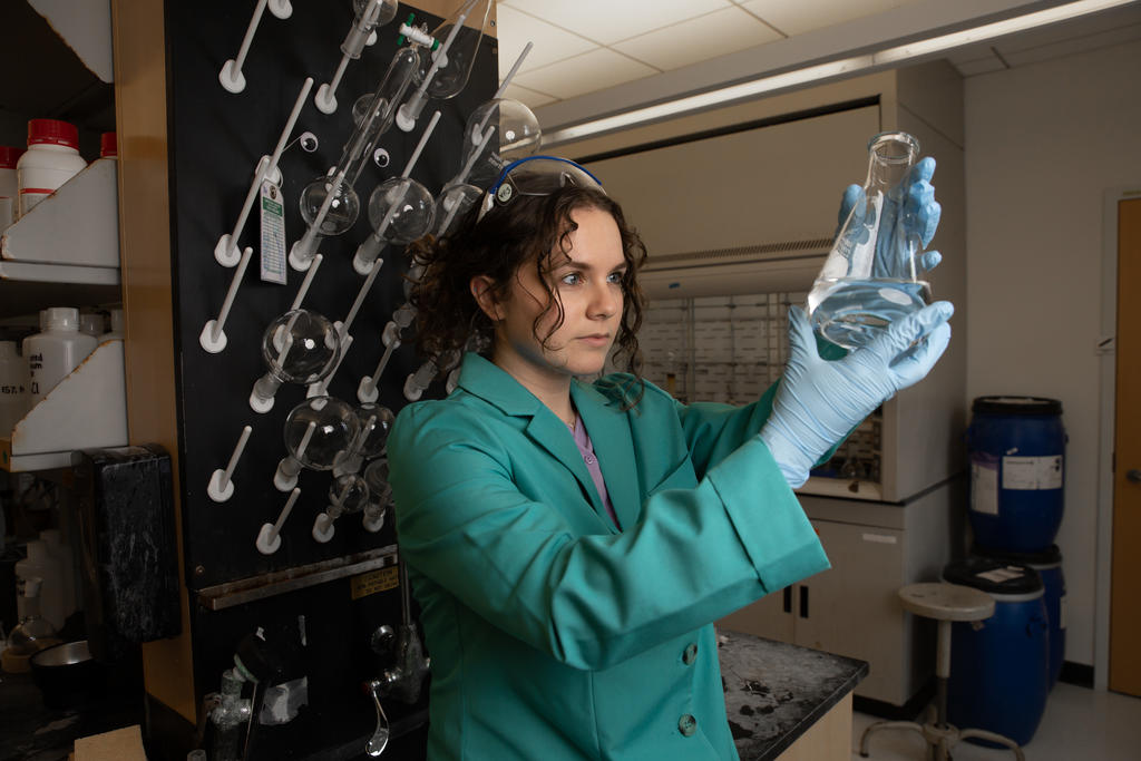 A college science student examines a flask 