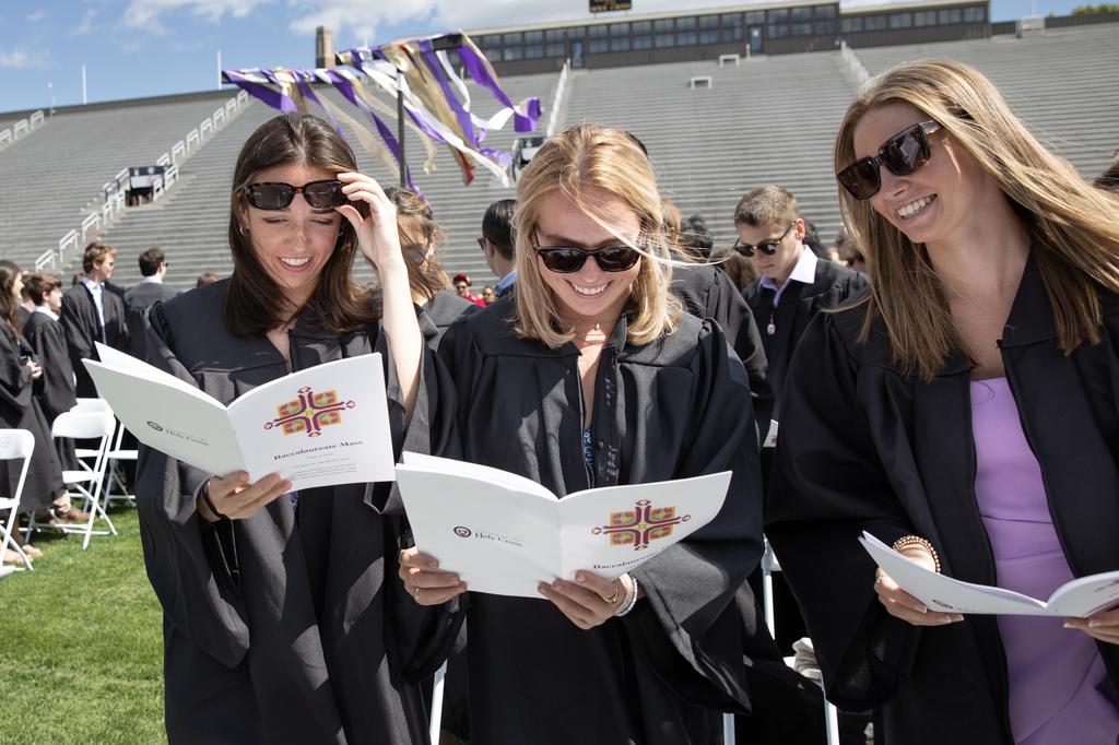 three students smile during a outdoor mass