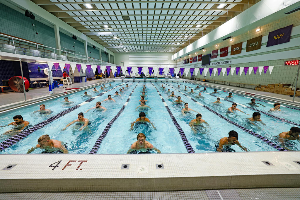 Football players in a pool exercising by treading water