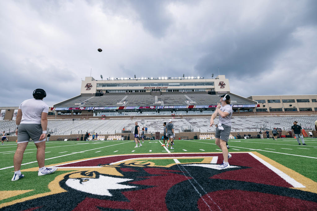 A man throwing a football on a football field