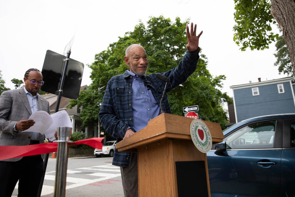 Man at podium waves at audience