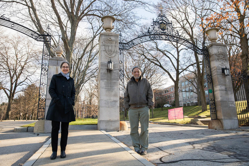 Man and woman stand underneath an iron arch