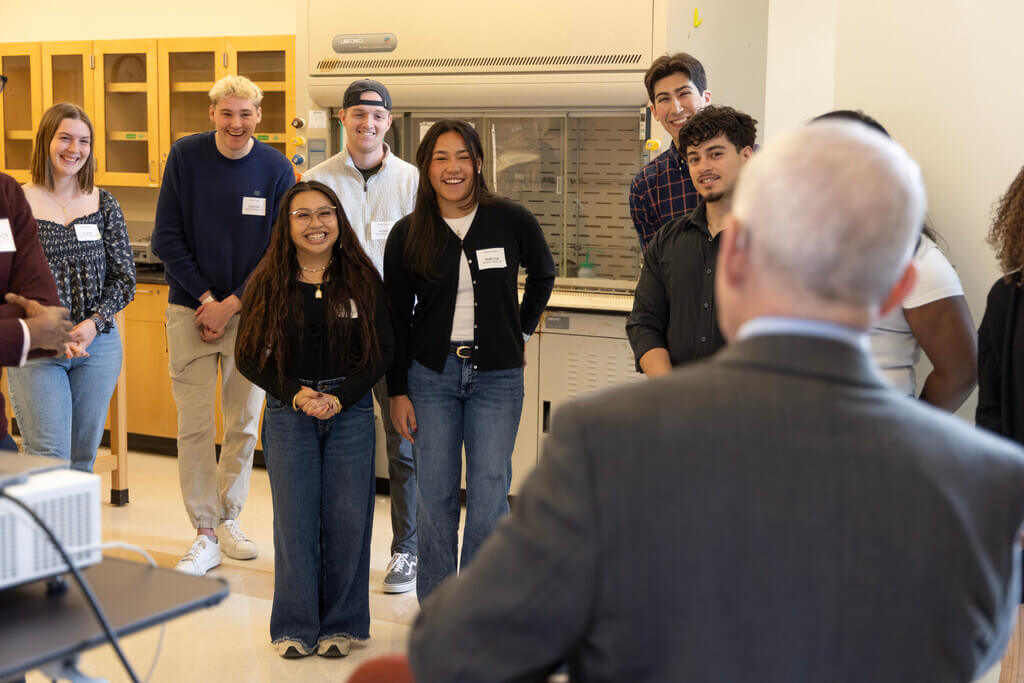 Group of young adults smile at a speaker