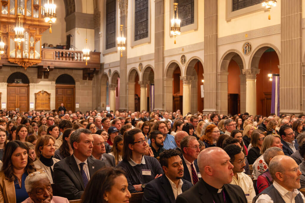 Crowd of people sitting in church pews