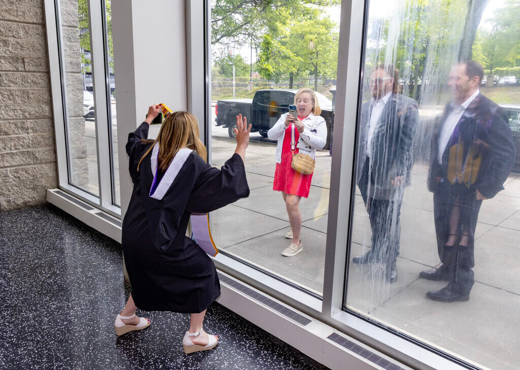 Student in cap and gown poses for picture 