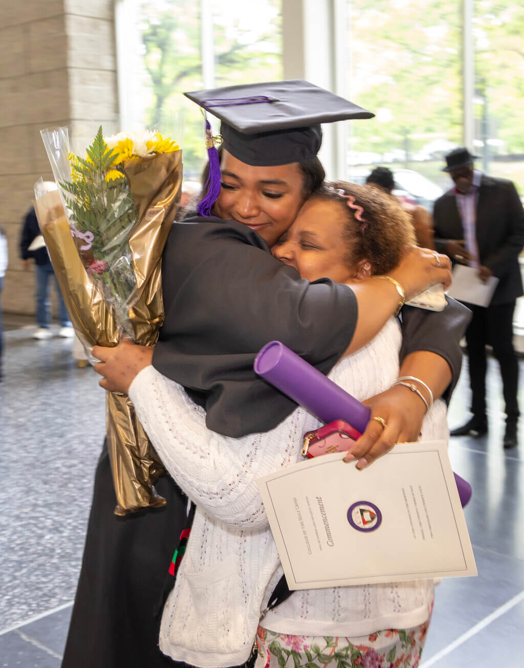 College graduate hugs a family member
