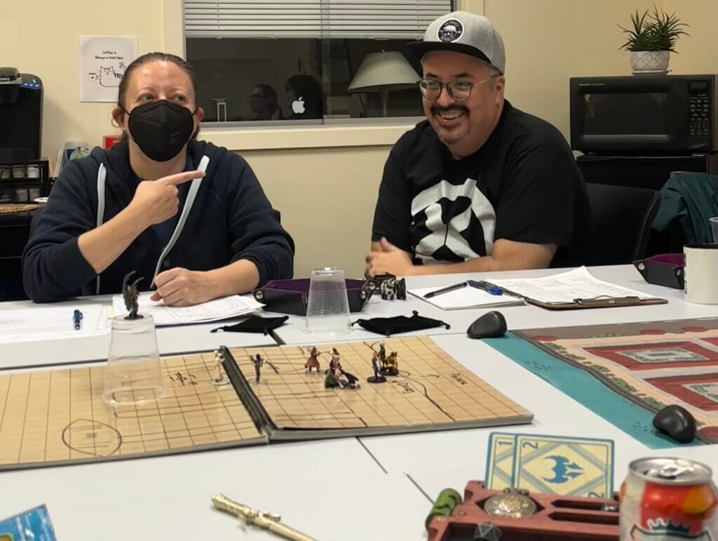 Woman in mask and Man in glasses sit at table