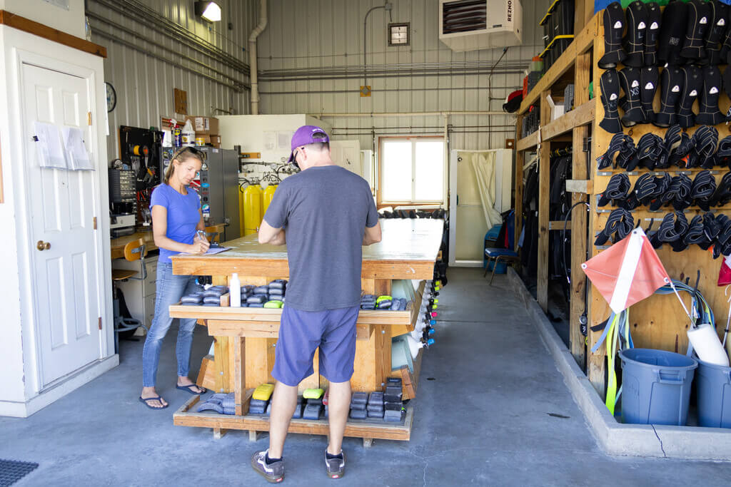 Two people in a warehouse full of scuba gear