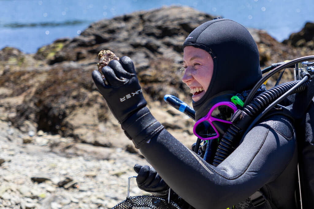 Scuba diver smiling at a piece of coral
