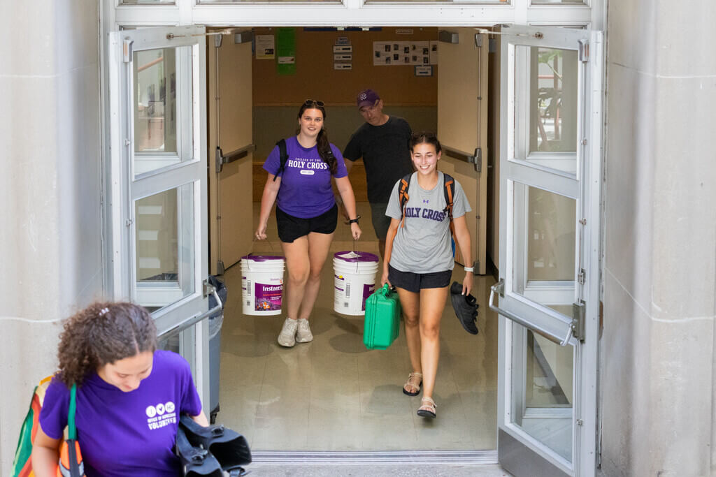 People carrying buckets down a hallway