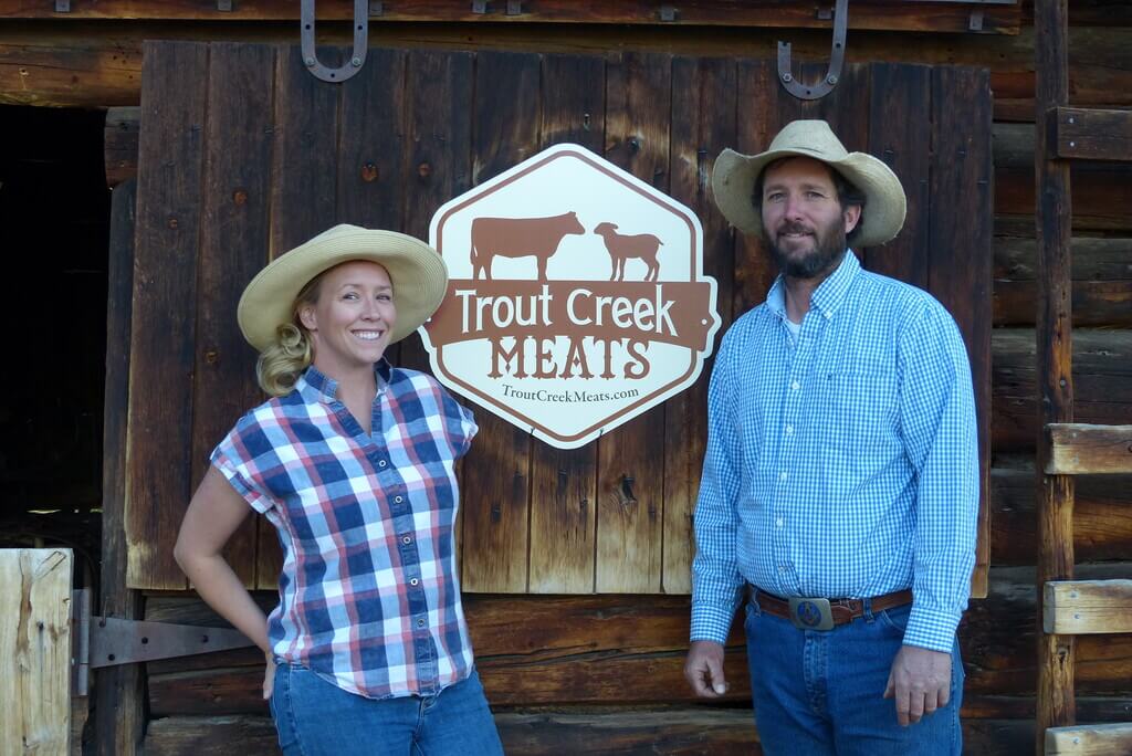 Megan Knott and Tyler Knott in front of Trout Creek Meats sign