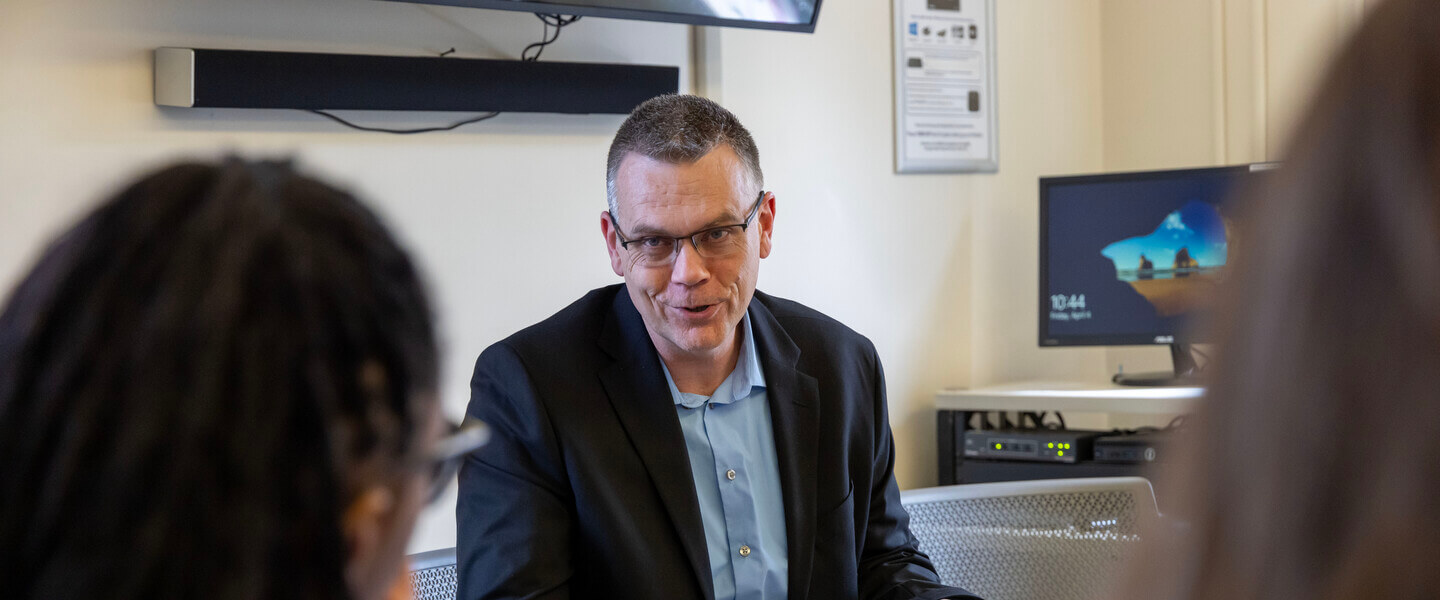 Man talking with students