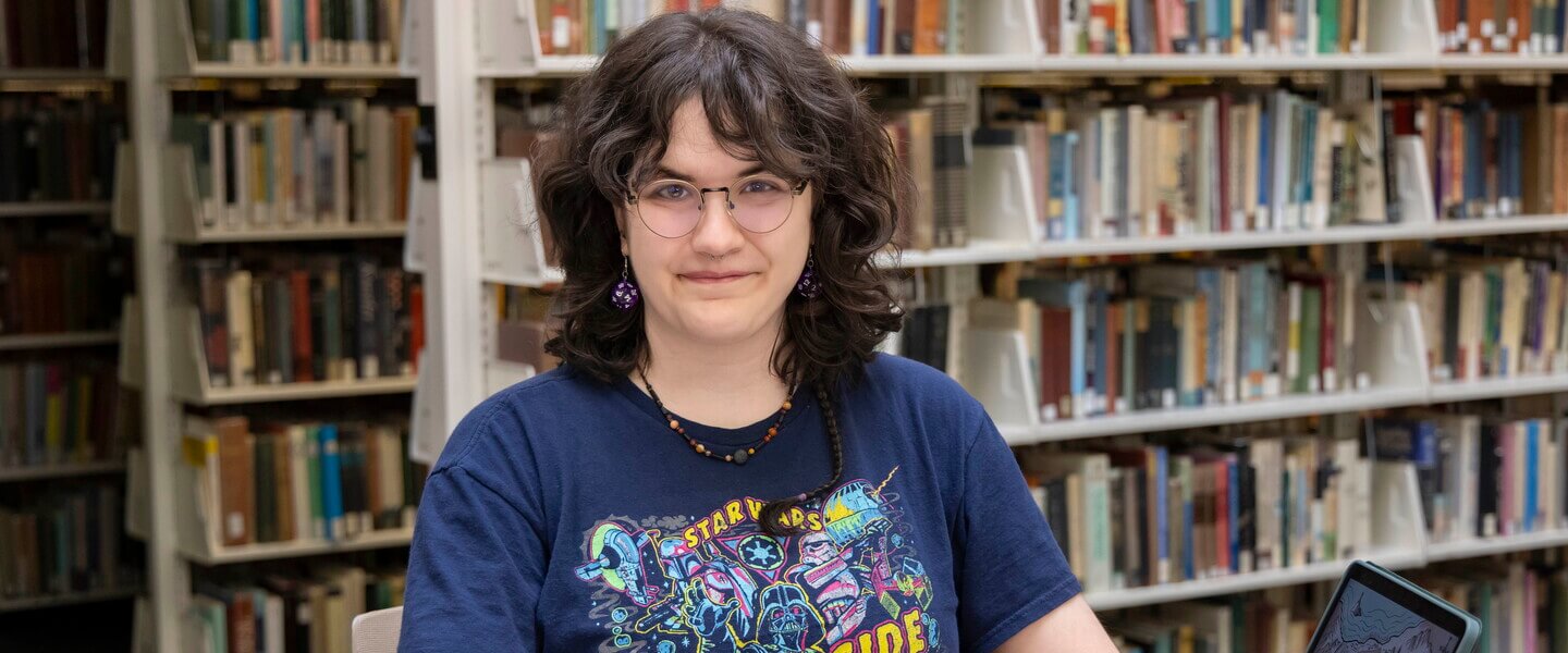 Person sits at table with an open book