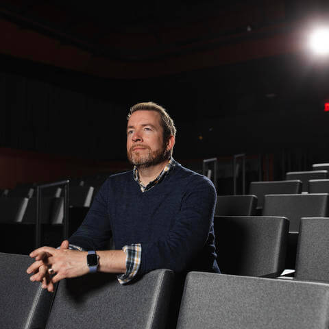 A man seated in a movie theater