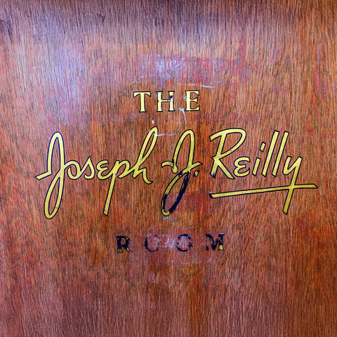 Black and gold lettering on a door reading "The Joseph J. Reilly Room"