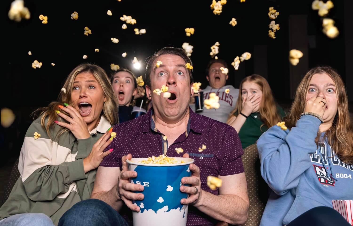 People with popcorn in movie theater