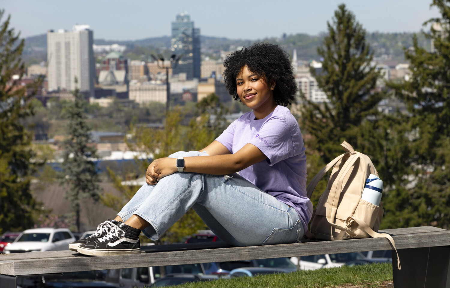 Bobbie Pitts sits on an bench on campus 