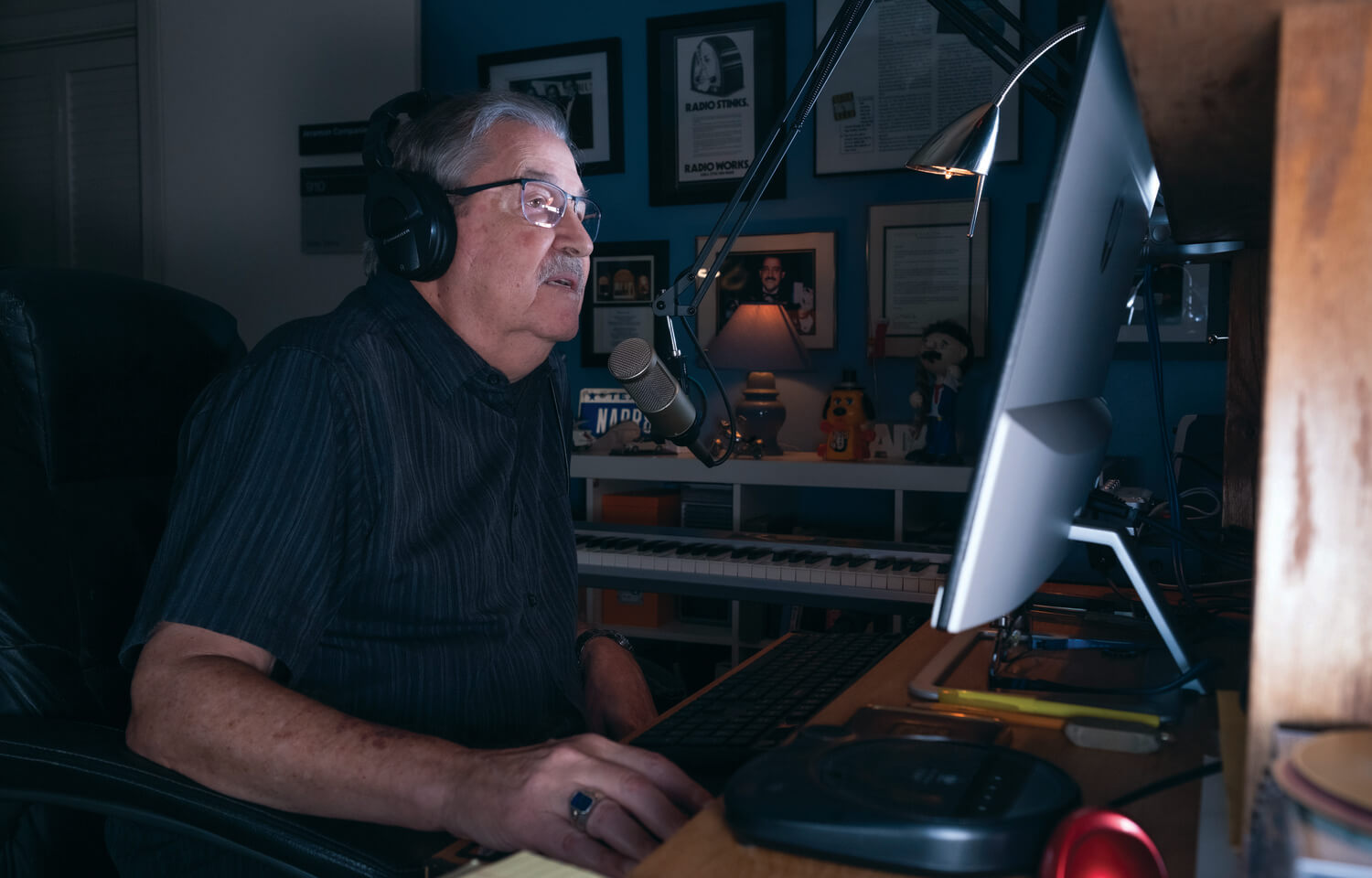 Seated man in glasses speaks into microphone