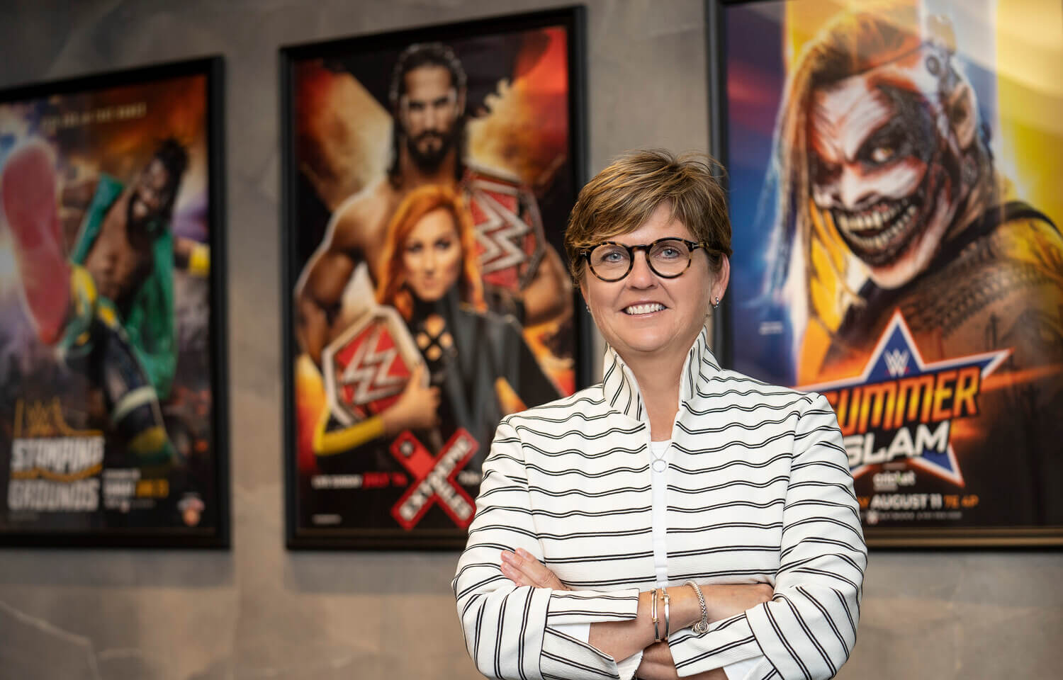 woman stands in front of three posters