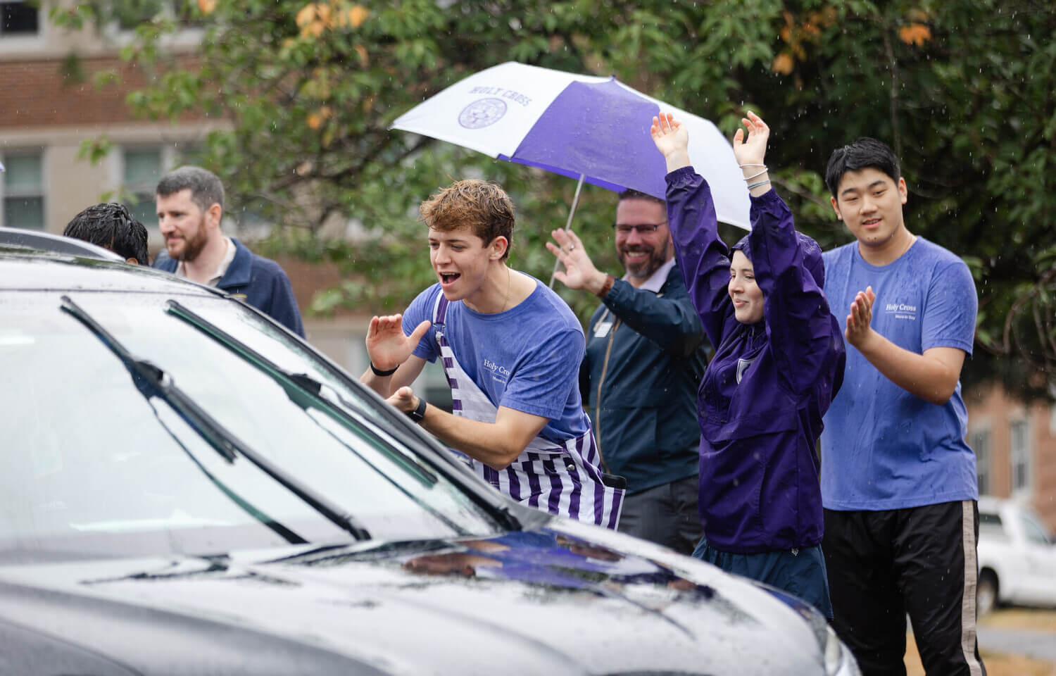 Students cheering as a car arrives