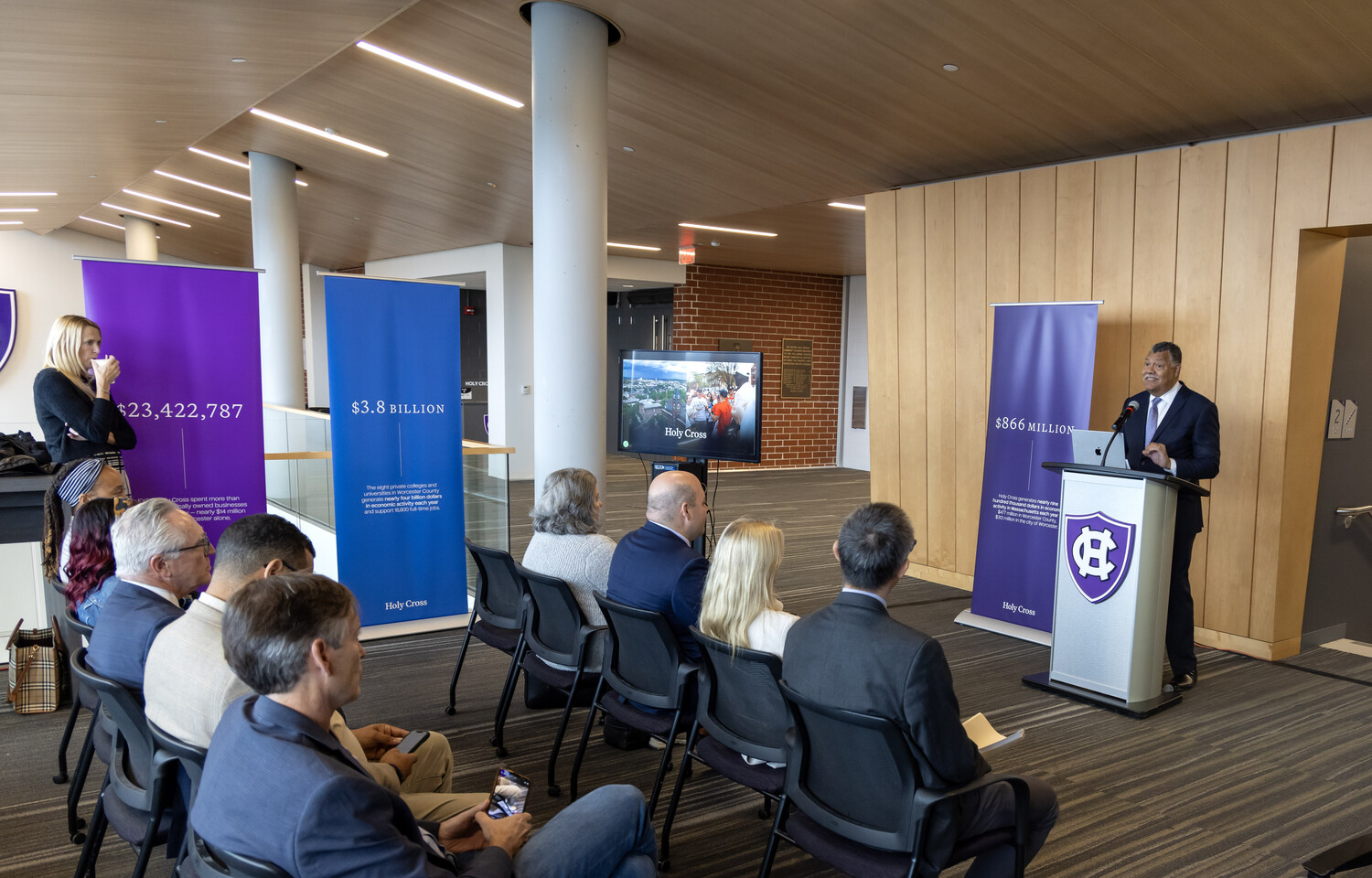 man at podium addresses crowd