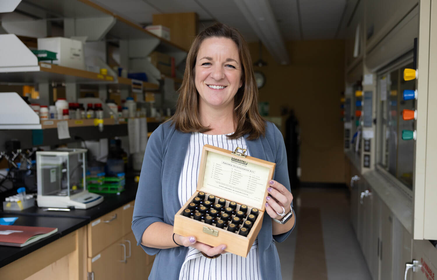 Woman holding a box containing tiny glass bottles