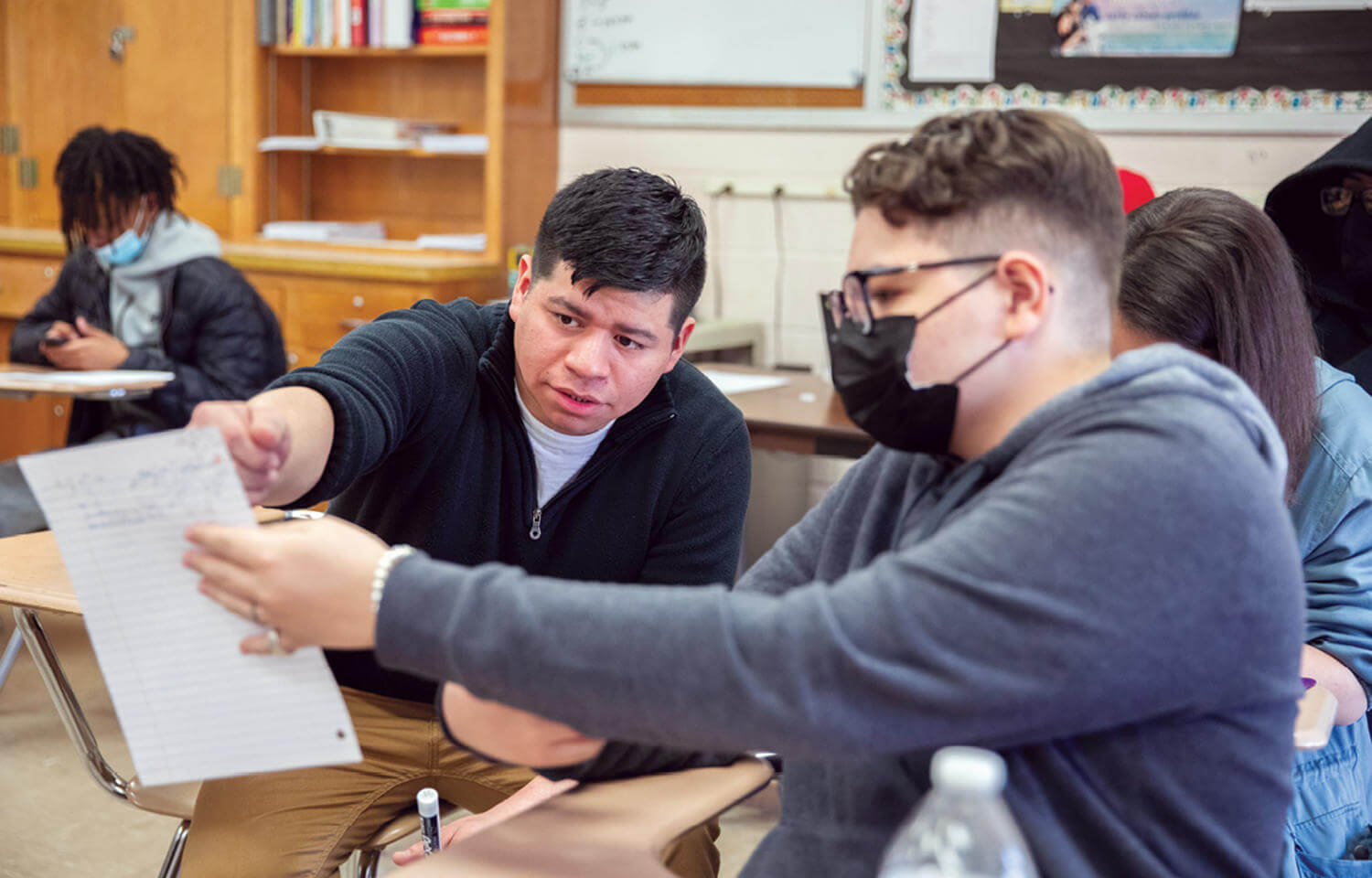 Josh Delgado '15 is reviewing classwork with a student from his Honors Algebra II class.